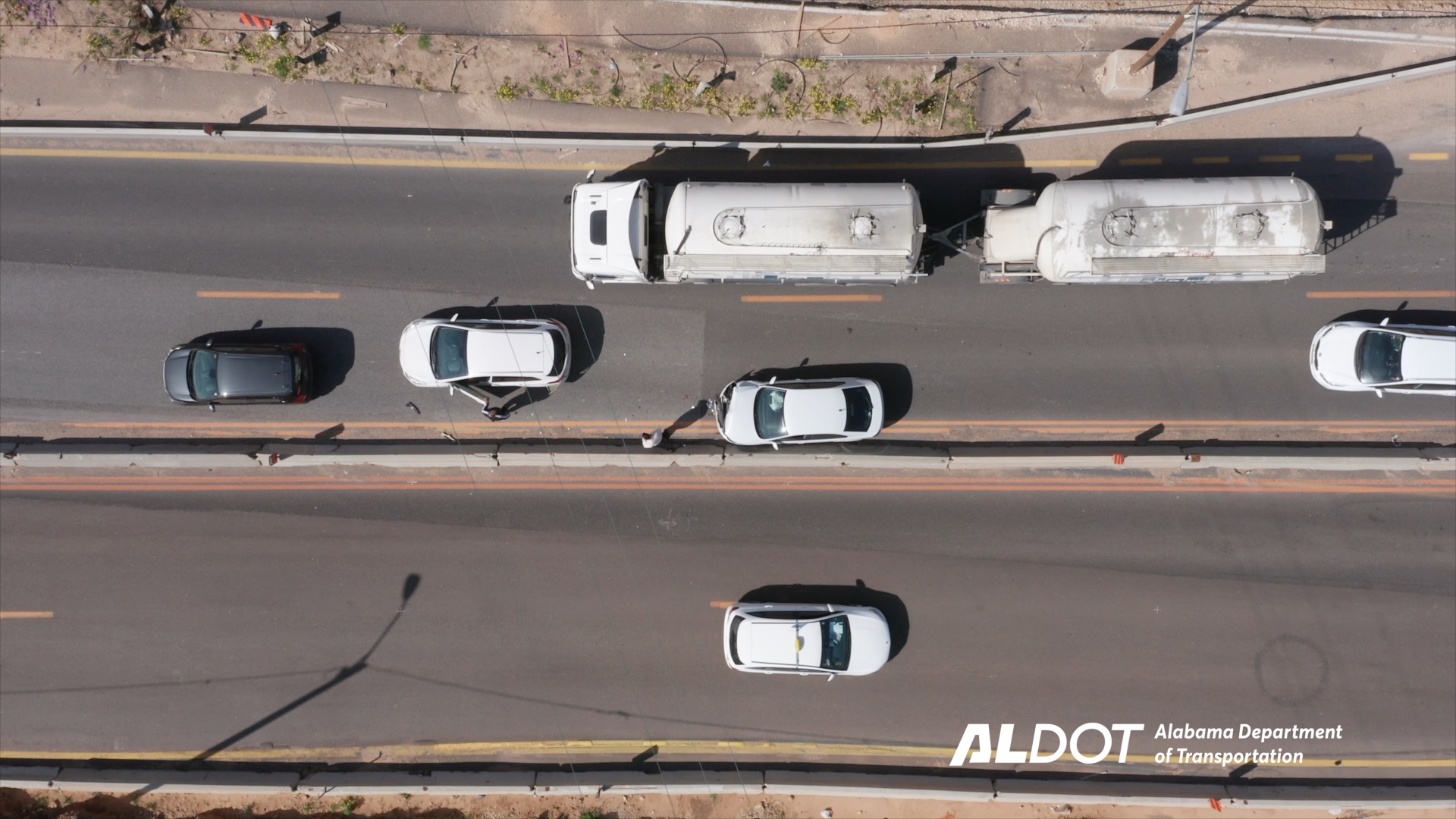 Trucks and cars traveling on a divided highway, as seen from above
