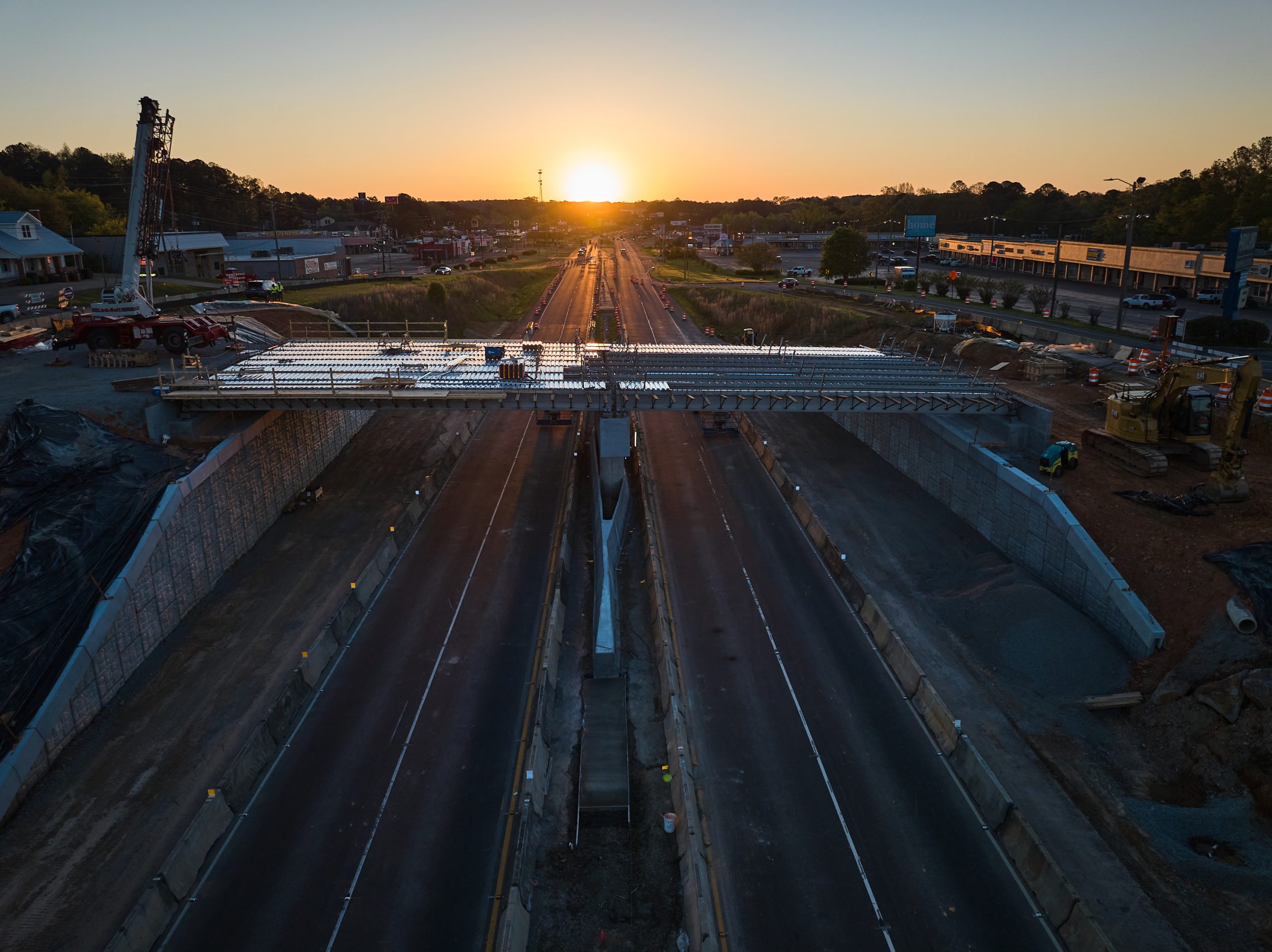 Aerial view of the SR-5 bridge under construction in Jasper with the sun rising in the background