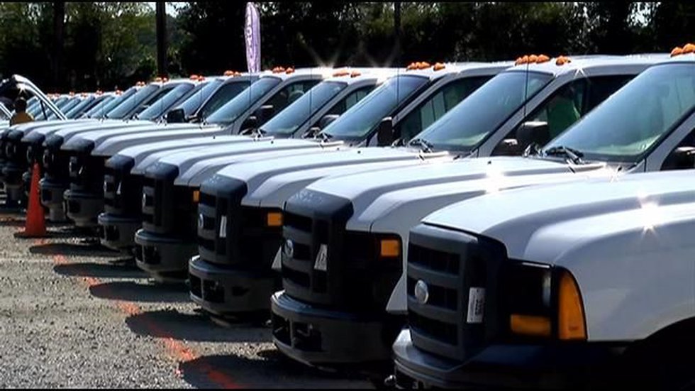 A long row of white pickup trucks