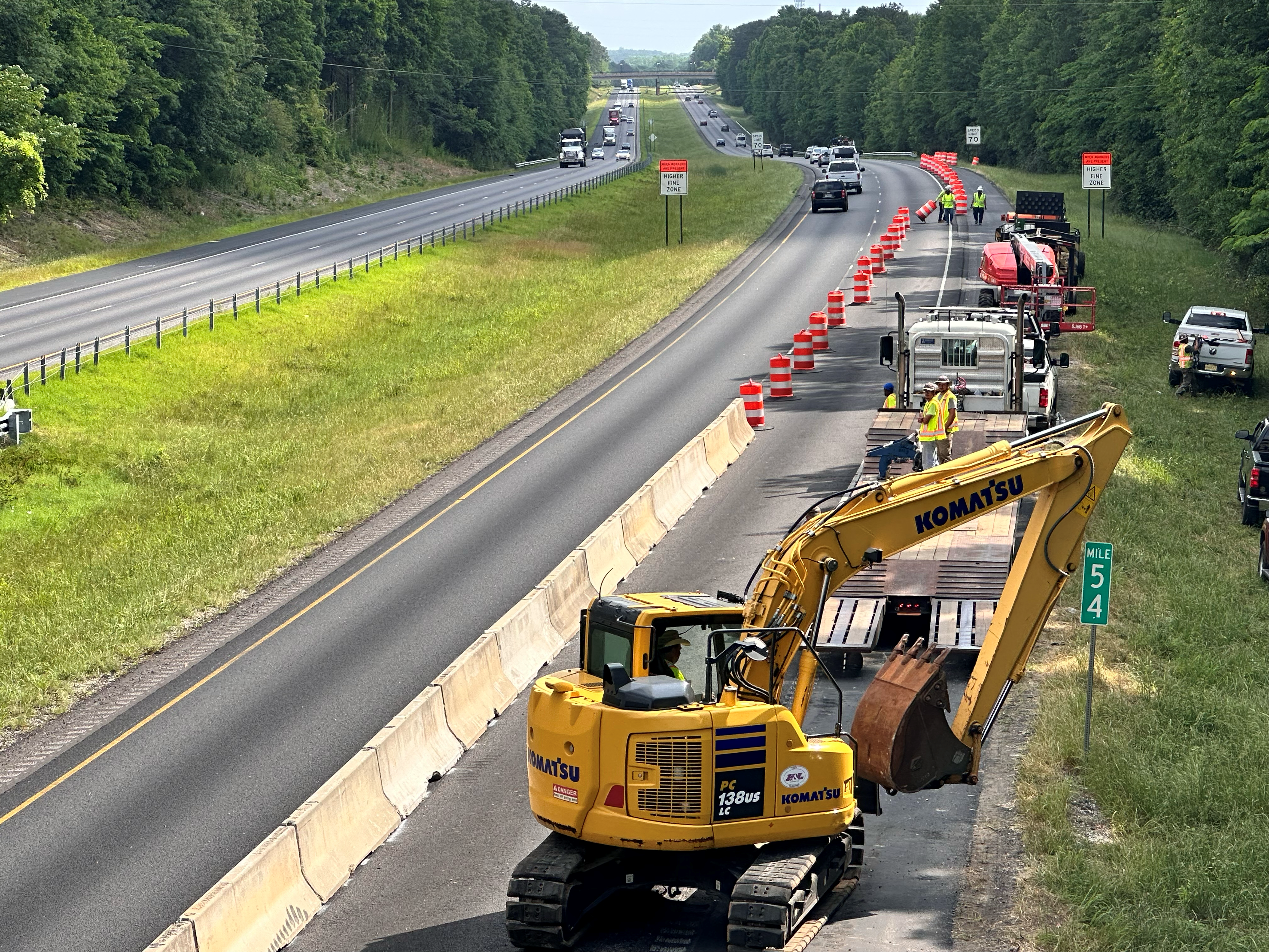 Contractor employees removing traffic control barrels and barrier to open all lanes of traffic to I-85 North at Wrights Mill Road.