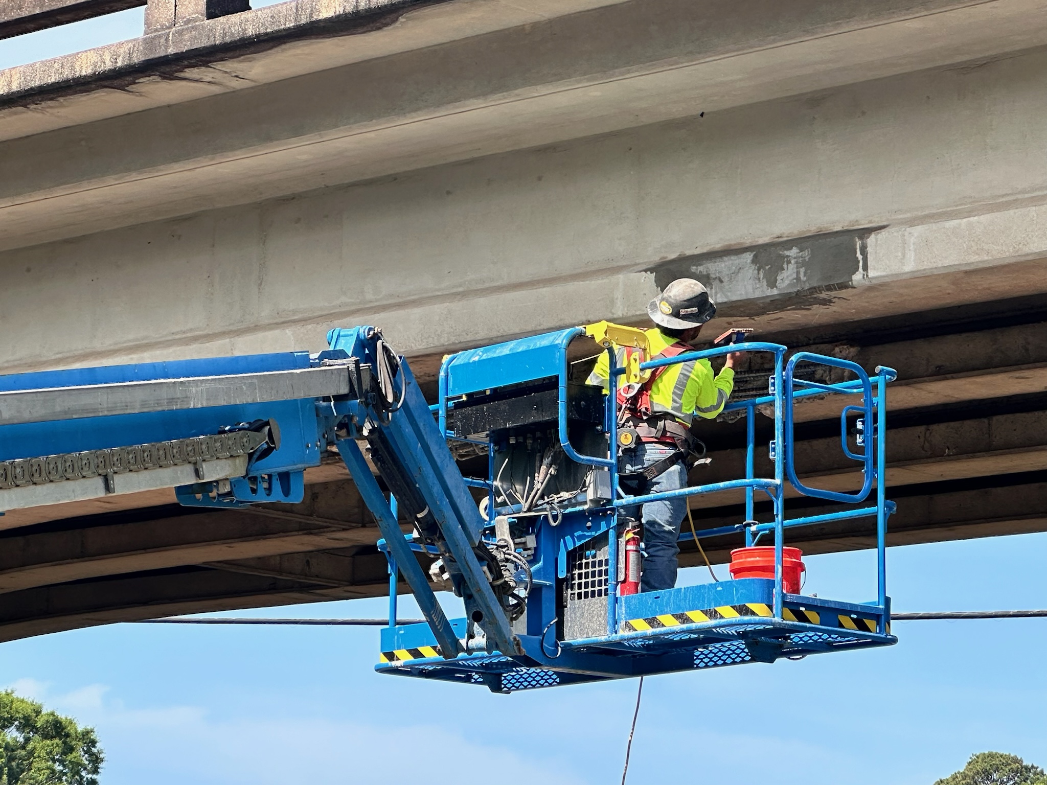 Person makes repairs to Wrights Mill Road bridge girders and concrete over I-85 North in Lee County.