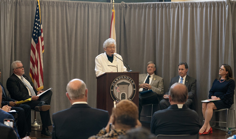Governor Kay Ivey behind a podium giving a speech.