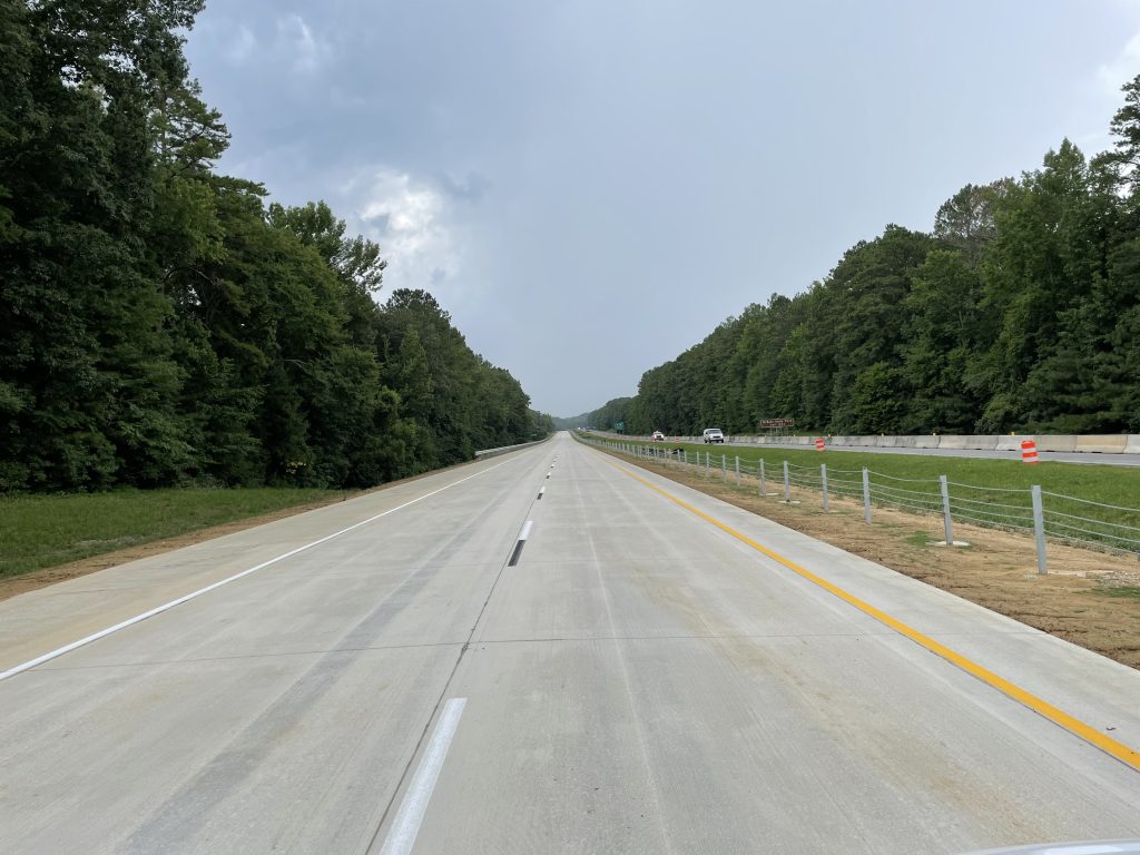 An empty concrete roadway, striped and ready to be opened to traffic.