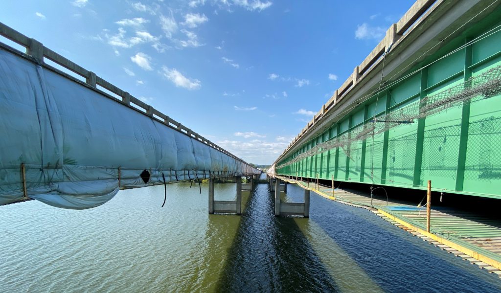 A view between two bridges with scaffolding and containment.