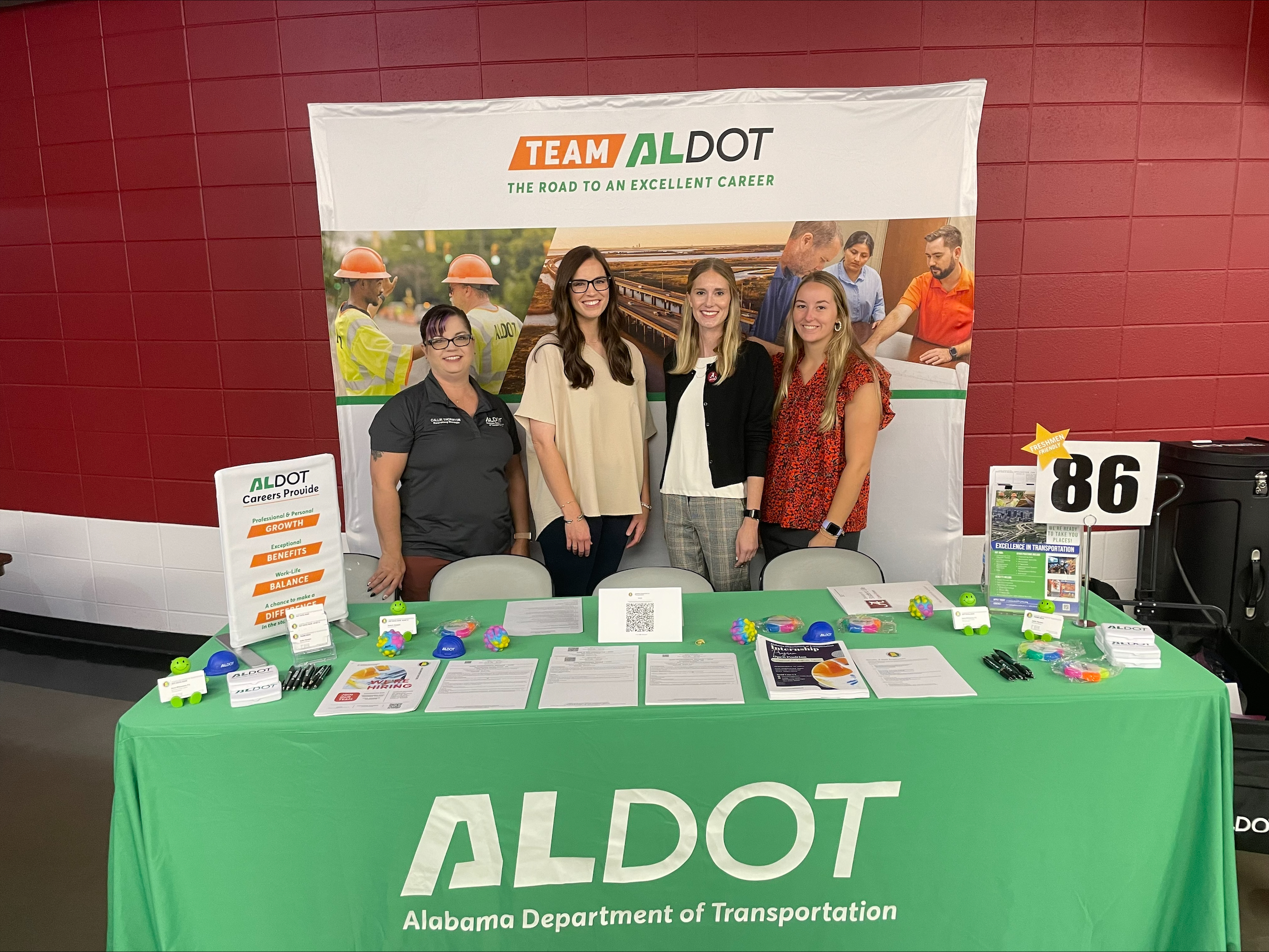 Callie Thornton, Caitlyn Wright, Darby Campbell, Ashlyn Huey standing behind a table with ALDOT recruiting materials on it