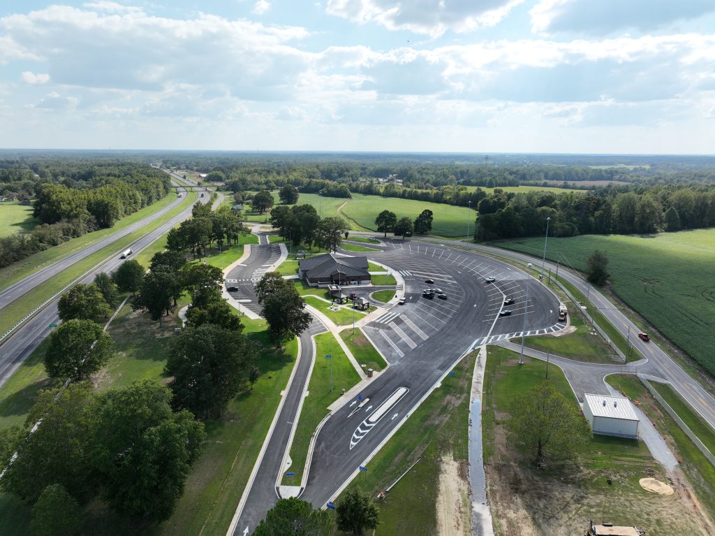 An aerial view of the Ardmore Welcome Center main building and grounds, with the building between two parking lots. I-65 can be seen to th east.