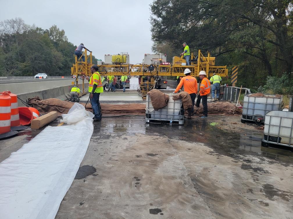 Multiple people working to rehabilitate a bridge deck.