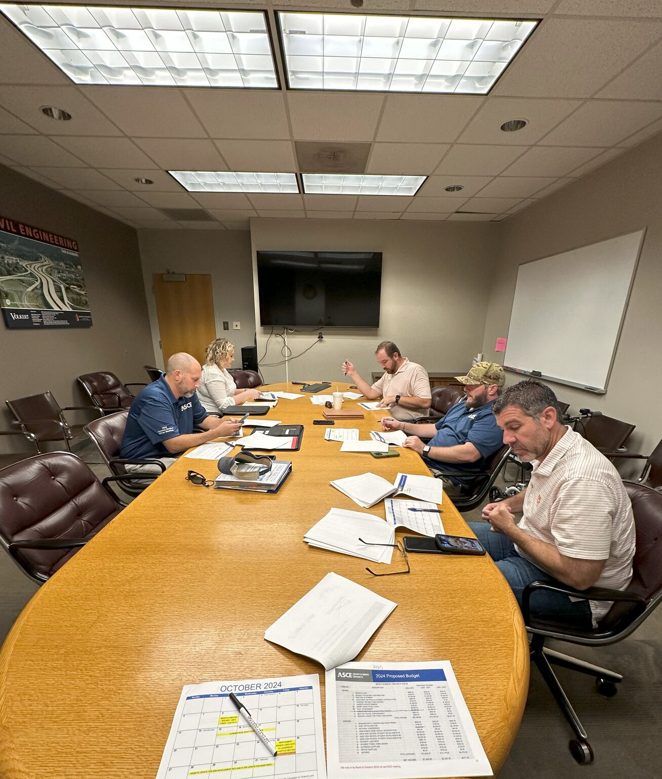 Members of a civil engineering board sitting around a conference table networking.