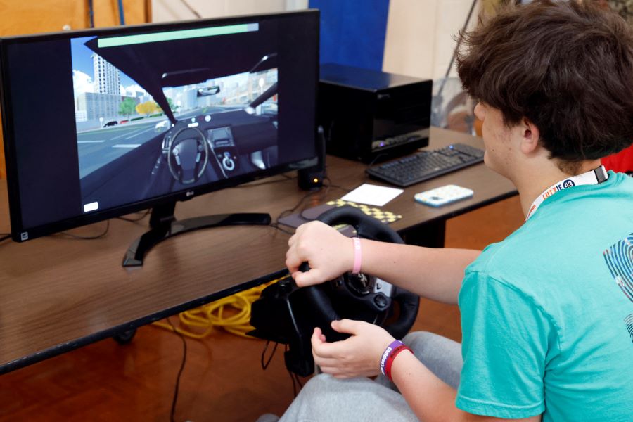 Teenage boy using a distracted driving computer simulator.