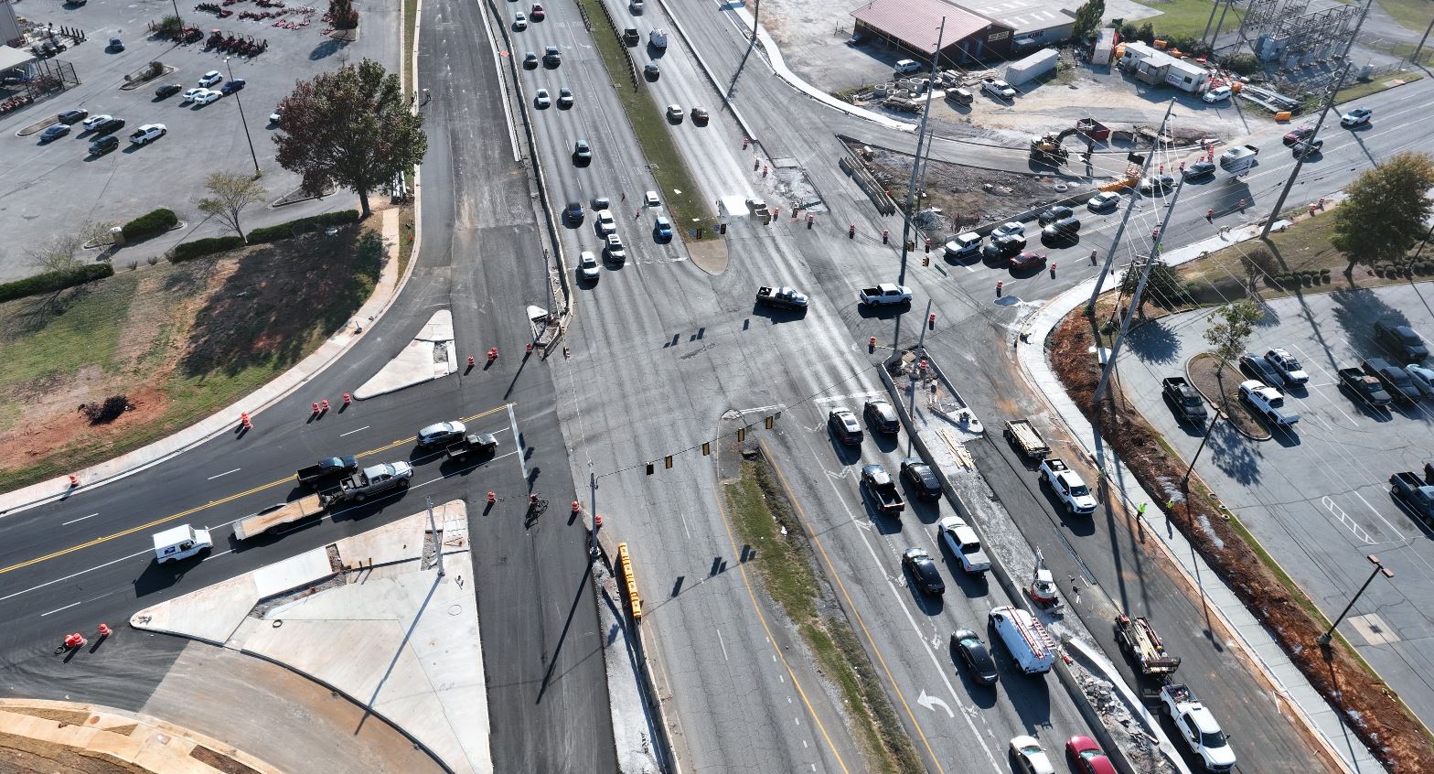 An overhead view of traffic at an intersection, with the empty lanes of the service road visible beside the busy mainline.