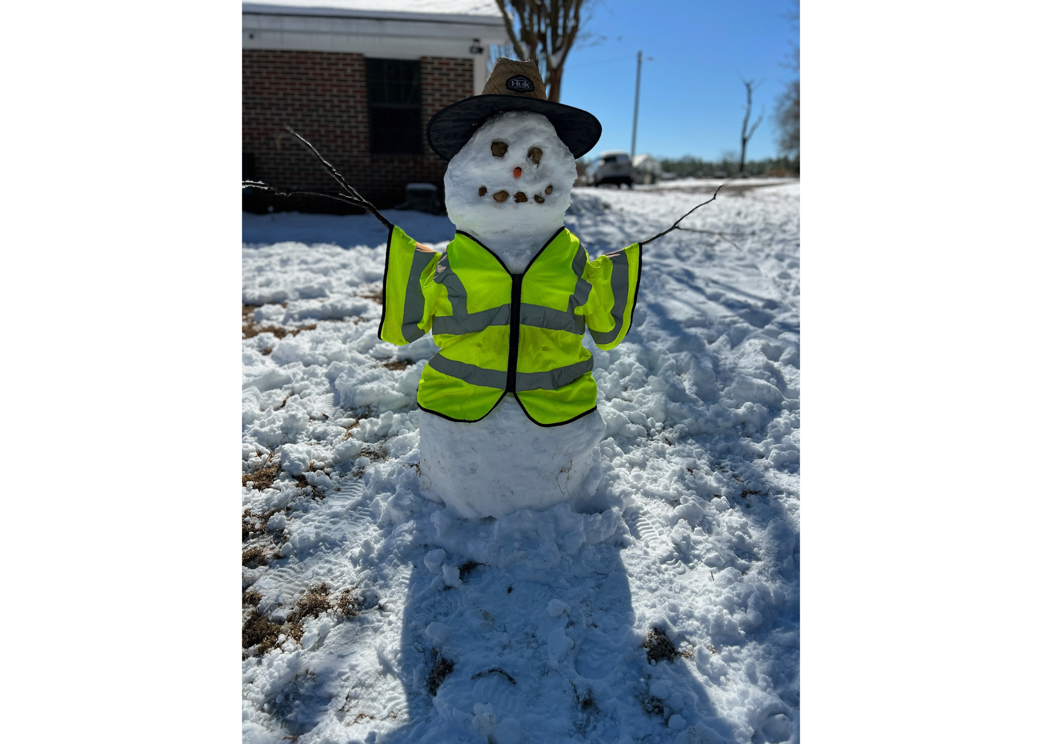 a snow man with a safety vest on and hat