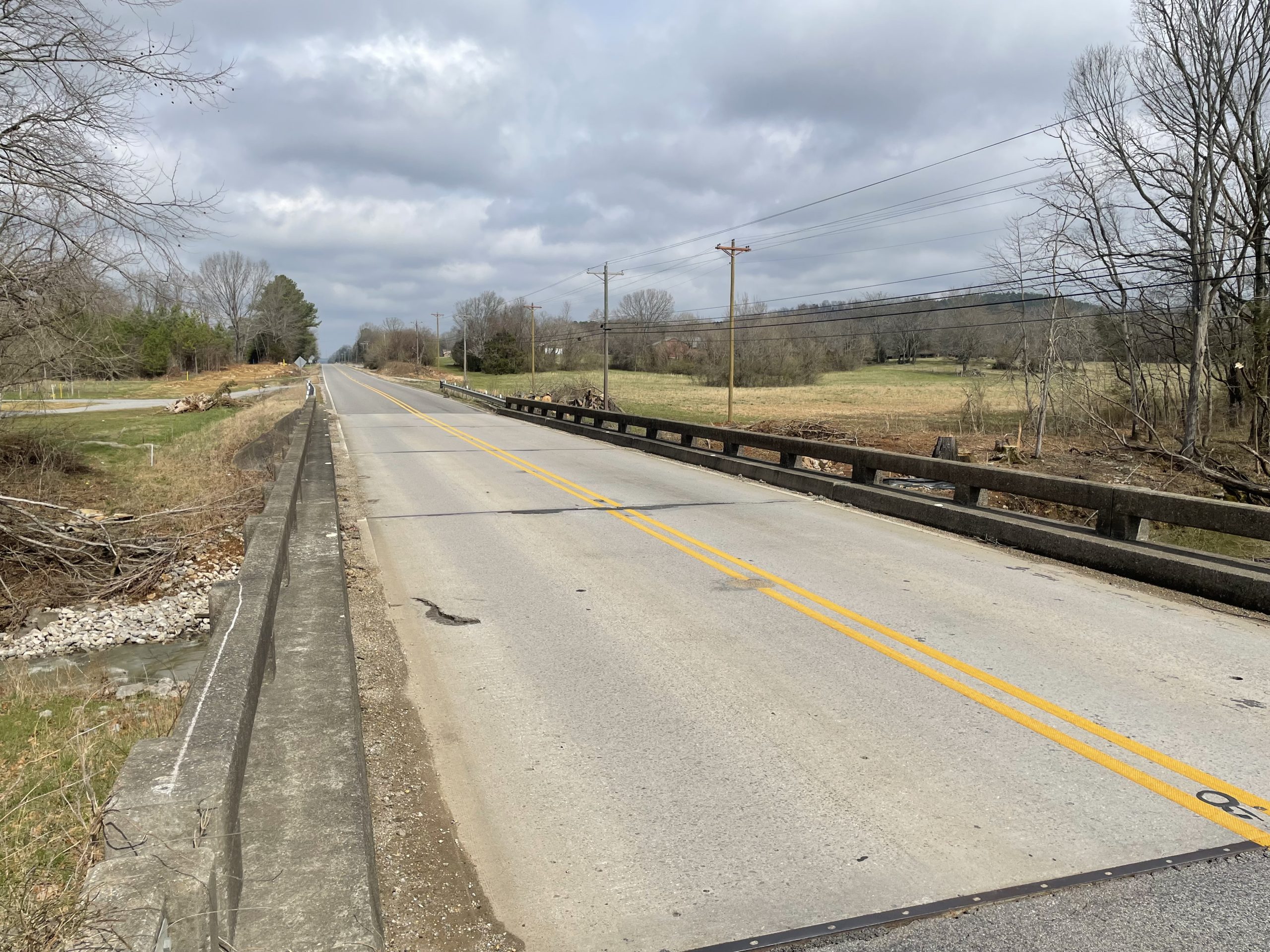The riding surface of a bridge on a rural highway, viewed from the roadway approach