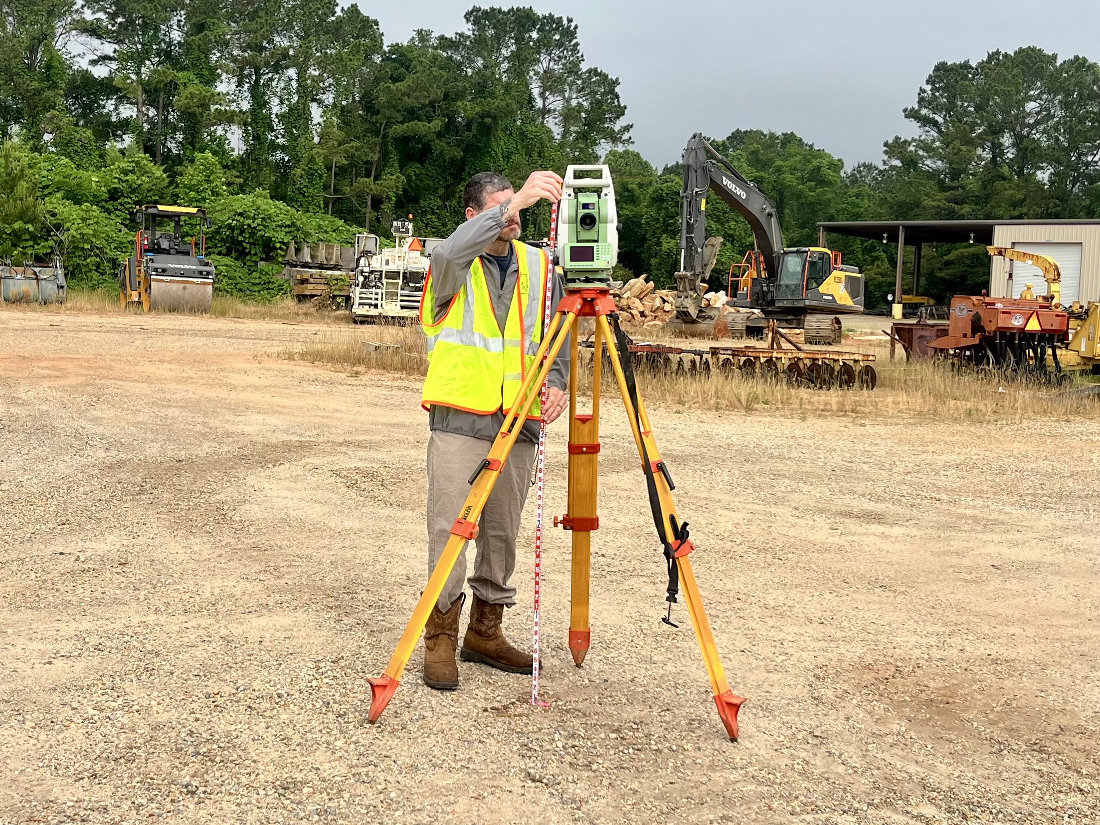 A member of ALDOT’s survey crew adjusts a total station at a construction site, demonstrating how ALDOT’s survey crew lays the foundation for success through precise measurements.
