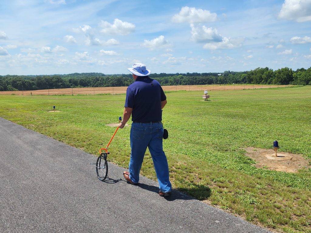 Airport inspector measuring runway lane widths.