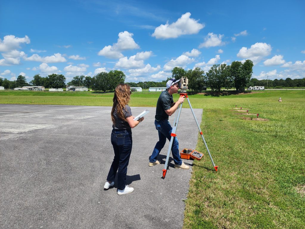 Photo of two airport inspectors while they inspect the approaches to the runway at Enterprise Municipal Airport.