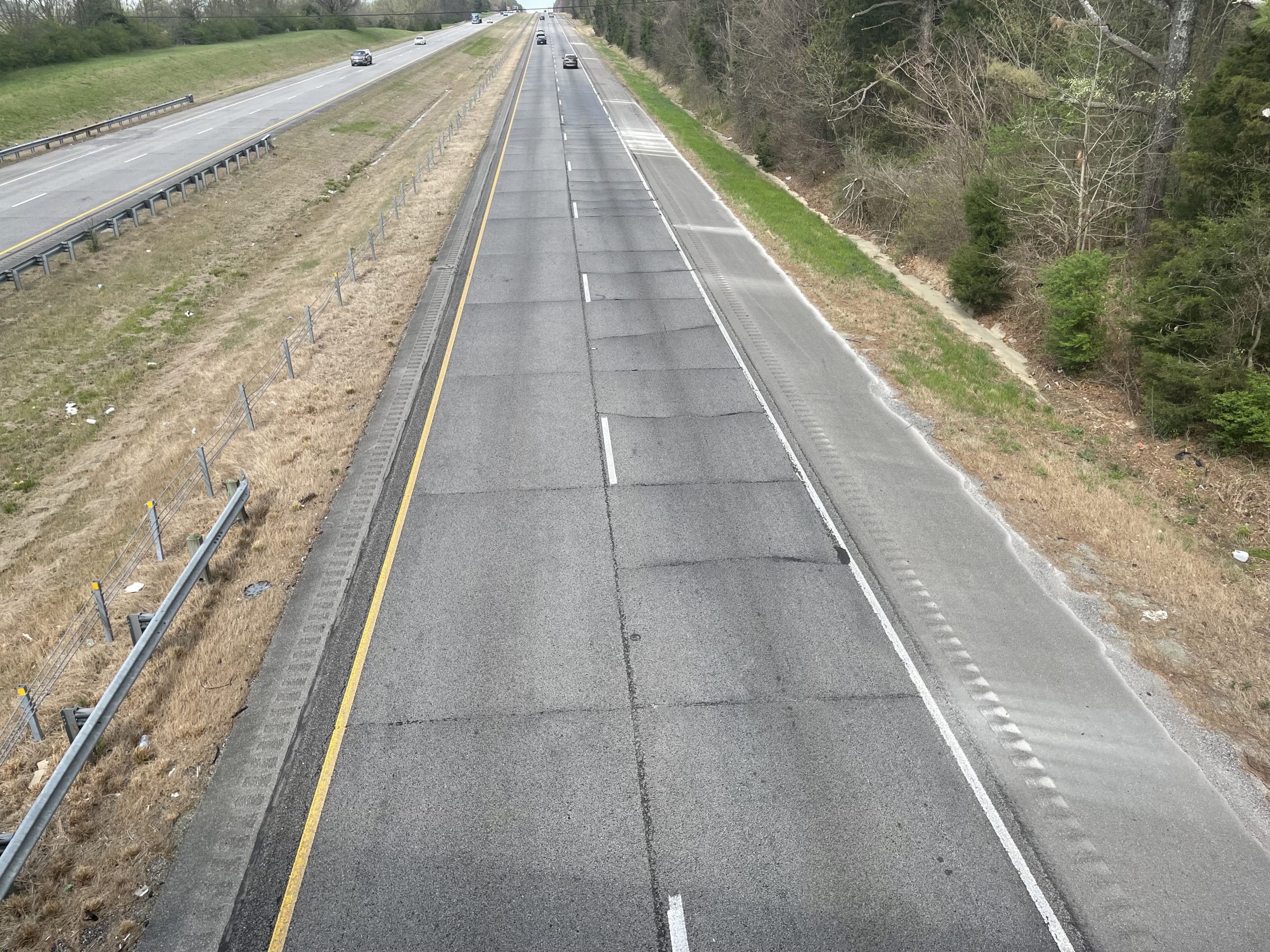 A two-lane roadway with bumps in the asphalt.