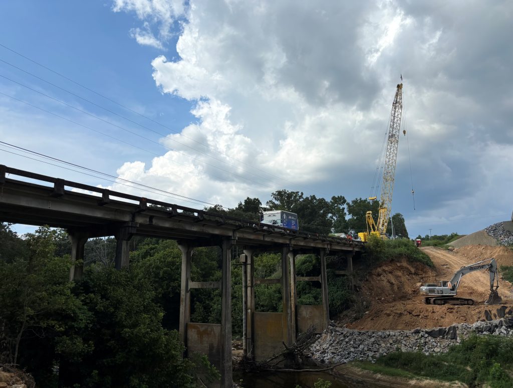 A large bridge crossing a creek between two hills