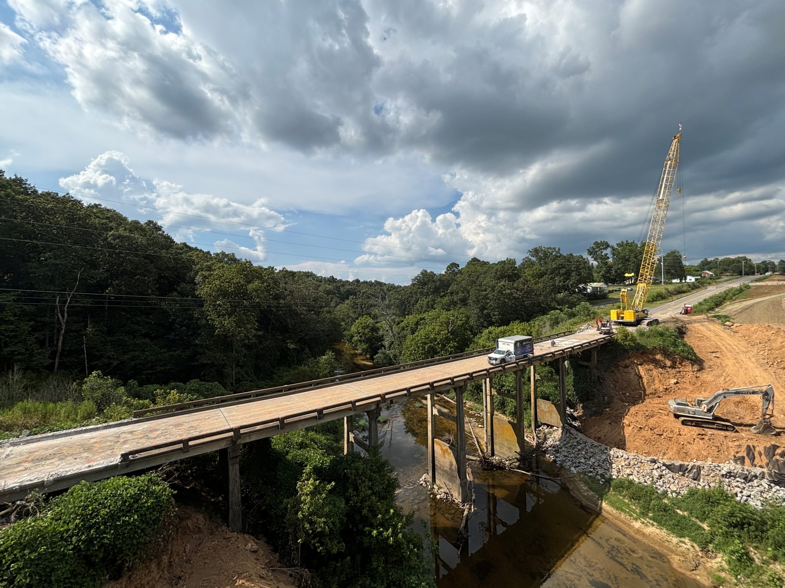 A large bridge crossing a creek between two hills