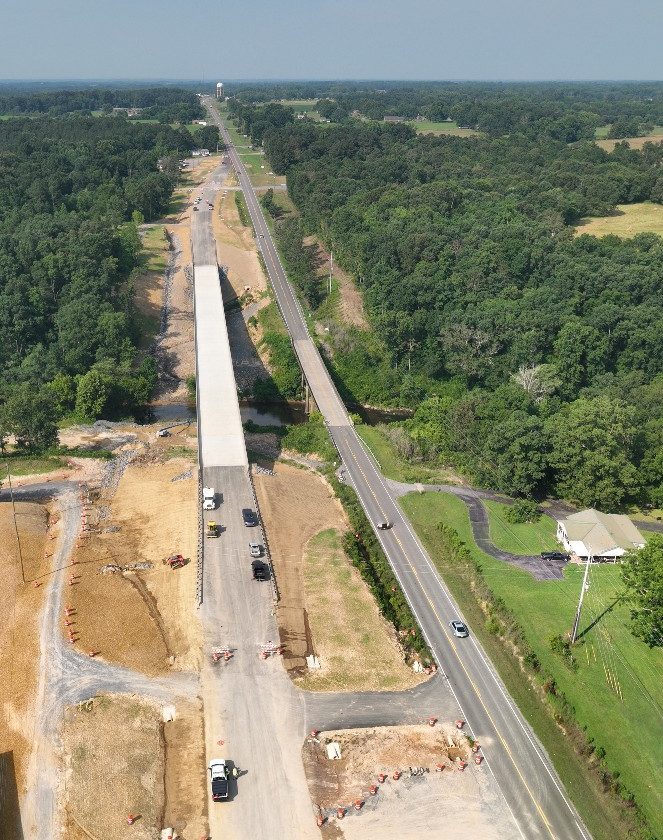 A new bridge, left, is much larger than the old bridge, right. The connection of the existing roadway and new bridge approach is visible in the background.