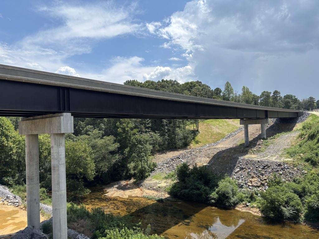 A large bridge crossing a creek between two hills