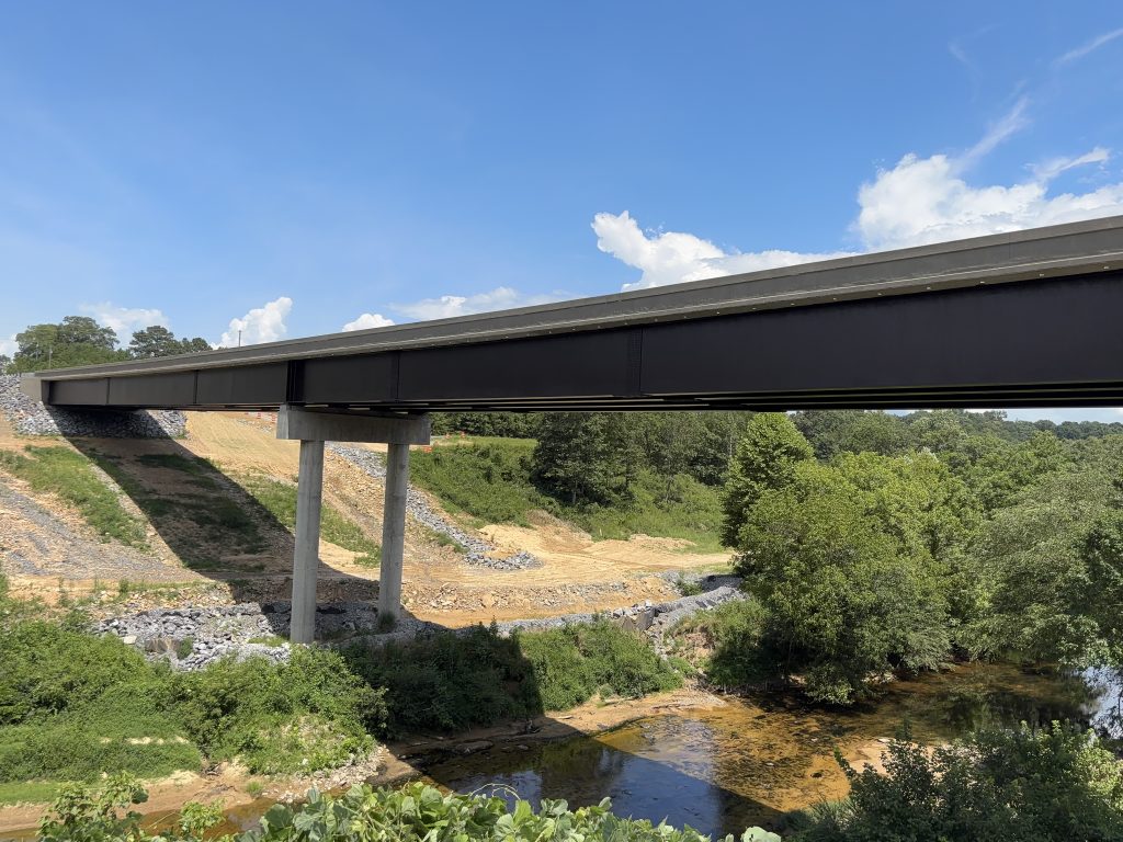 A large bridge crossing a creek between two hills