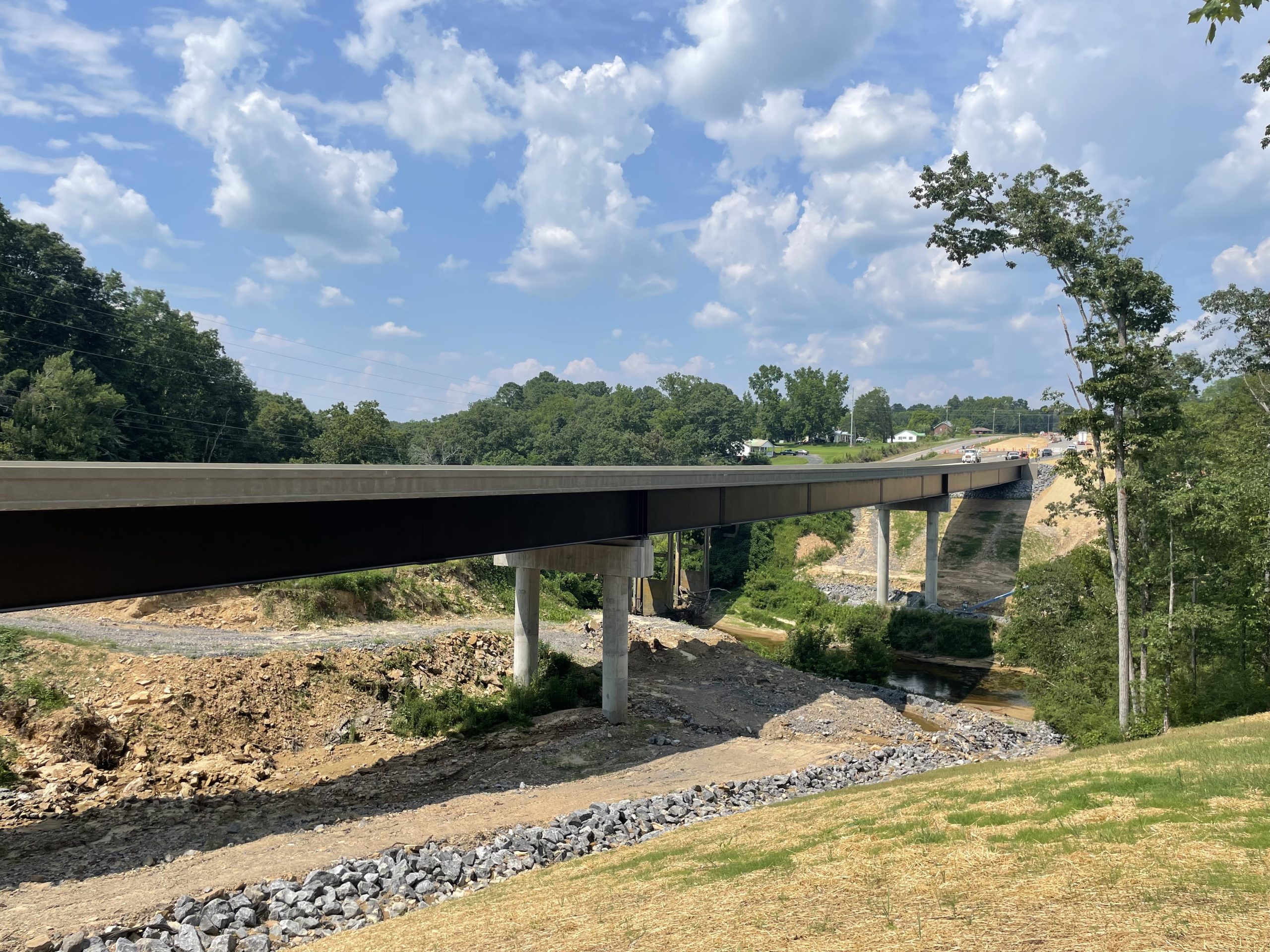 A bridge spanning a creek between two steep hills.