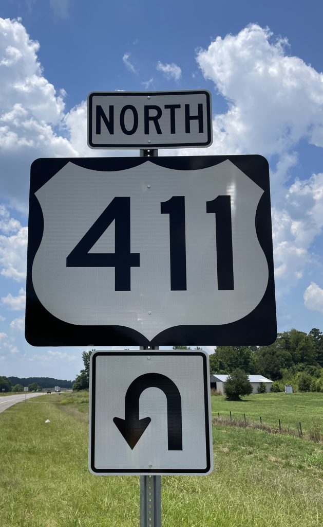 A sign indicating motorists must make a U-turn to get on US-411 northbound. 