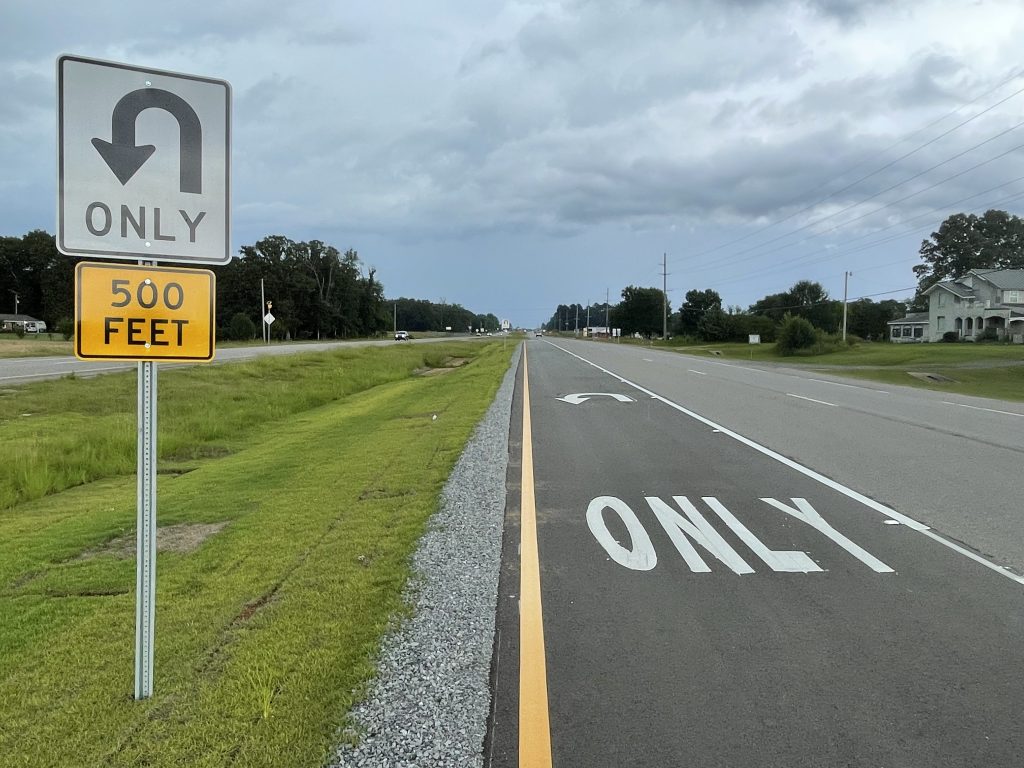 A lane marked for U-turns only and corresponding sign.