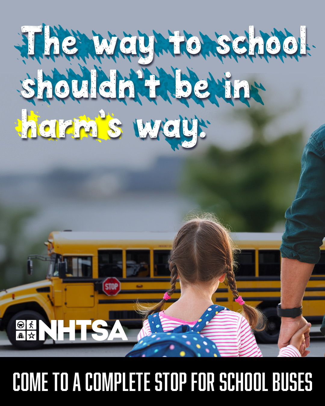 Child holding an adult’s hand while walking toward a stopped yellow school bus with its stop sign out. Text reads: “The way to school shouldn’t be in harm’s way.” NHTSA logo and message at the bottom: “Come to a complete stop for school buses.”