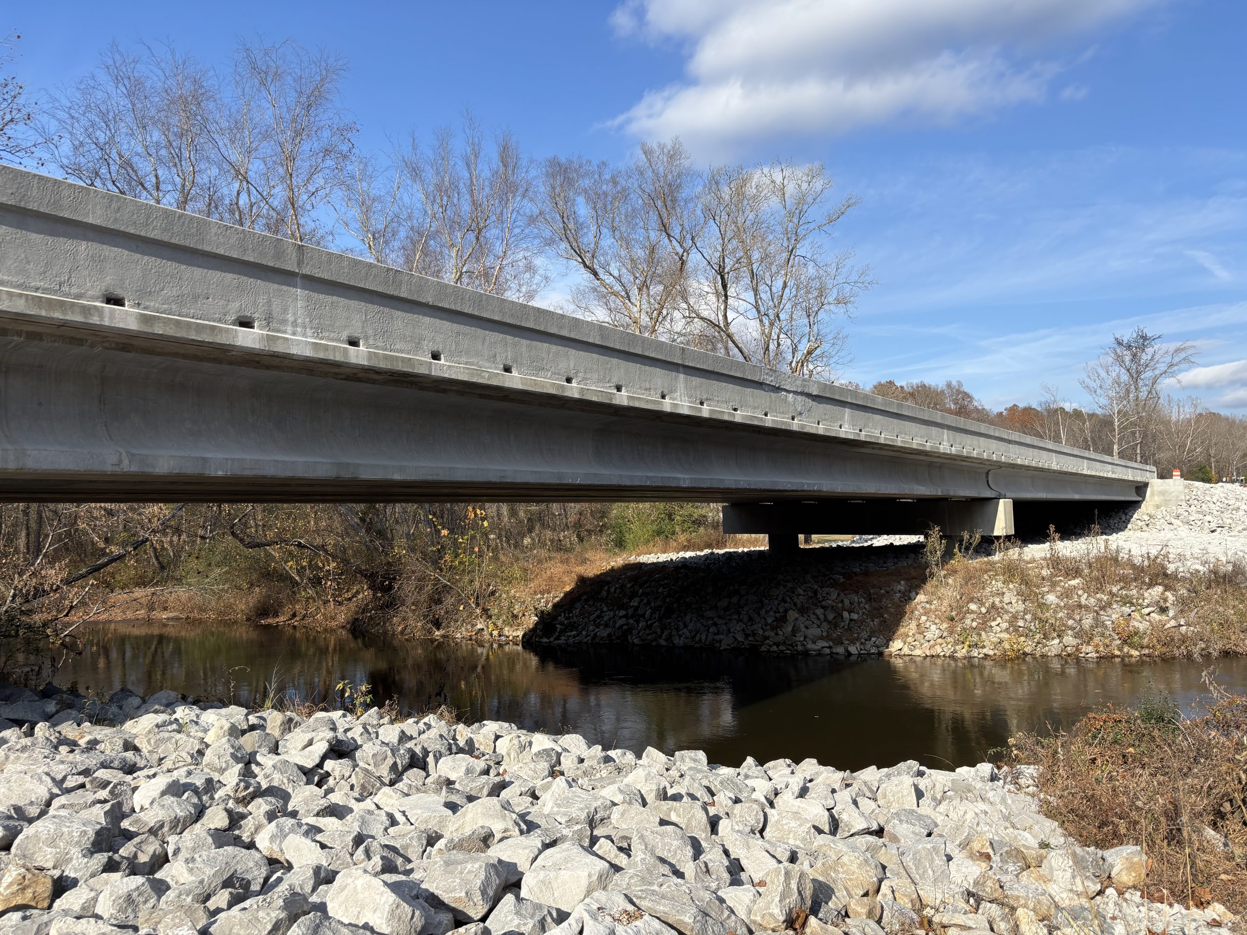 A bridge over a creek with stone on the banks
