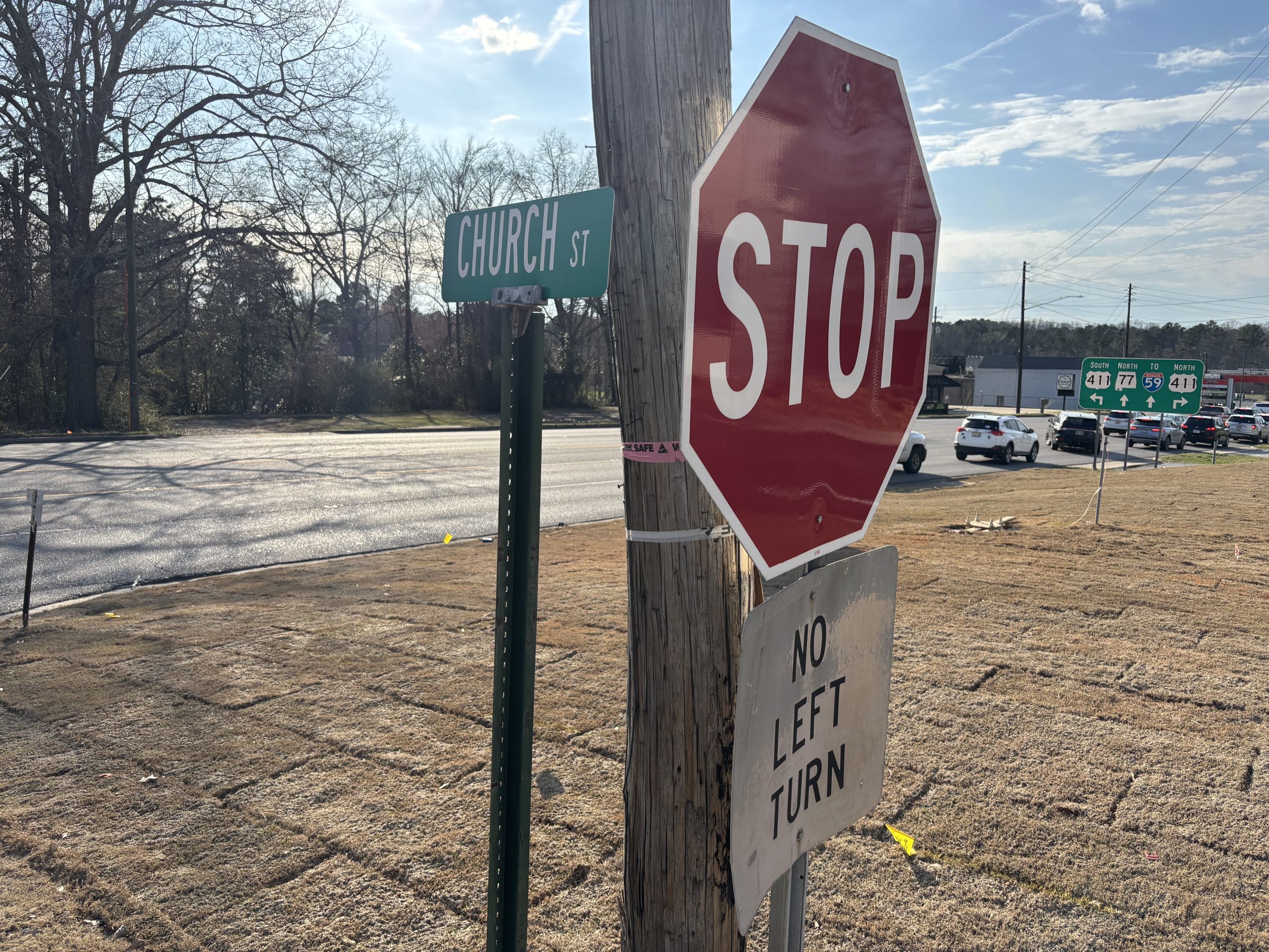 A green street sign reading "CHURCH ST" and a stop sign with a NO LEFT TURN placard are posted at the intersection of Church Street with SR-77.