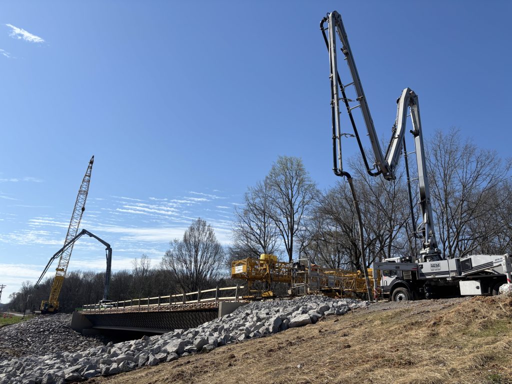 Boom pumps and cranes rise into sky over the new SR-243 bridge.