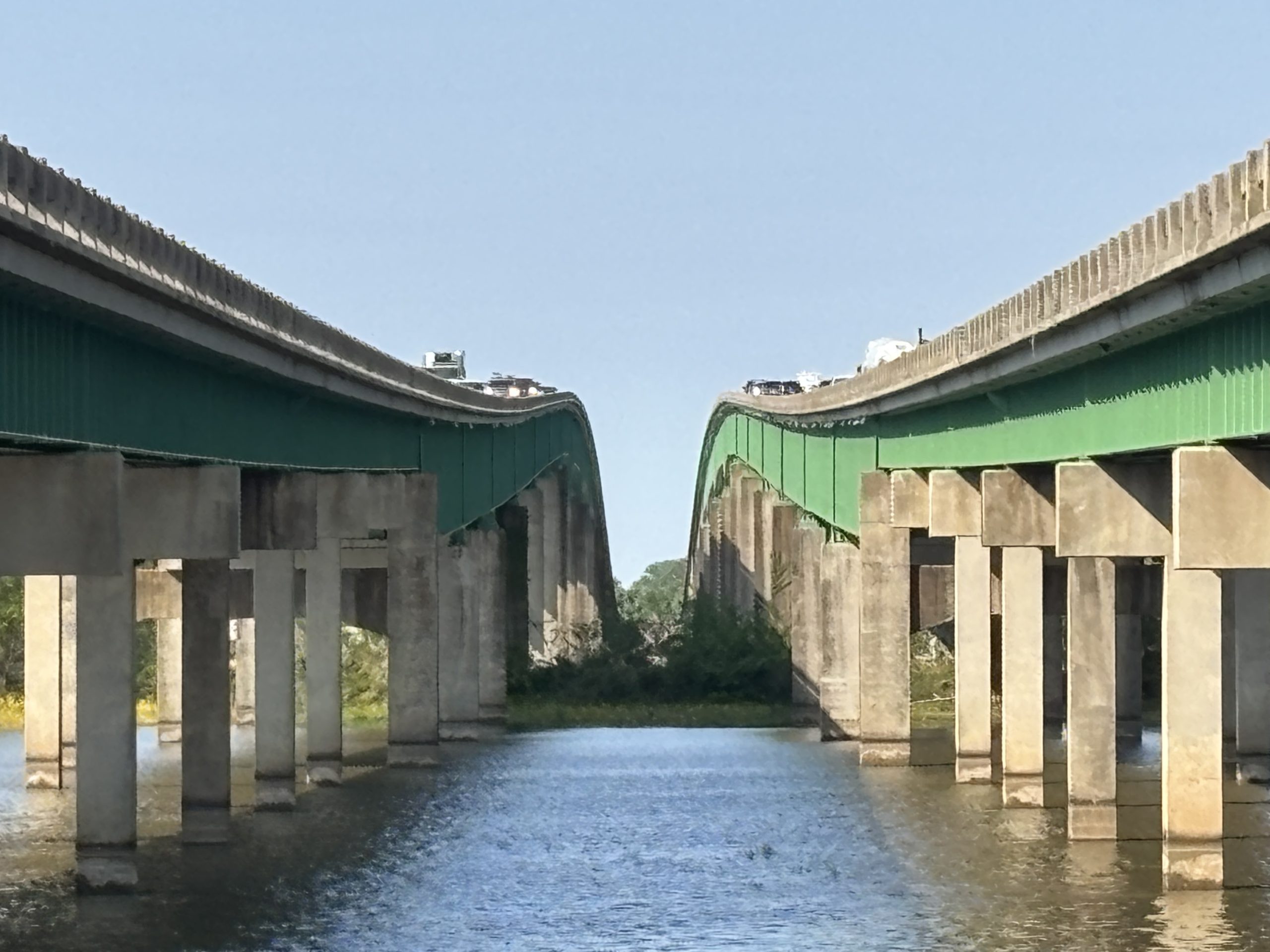 Two bridges over a river. Fresh green paint is visible on the steel elements of the bridges.