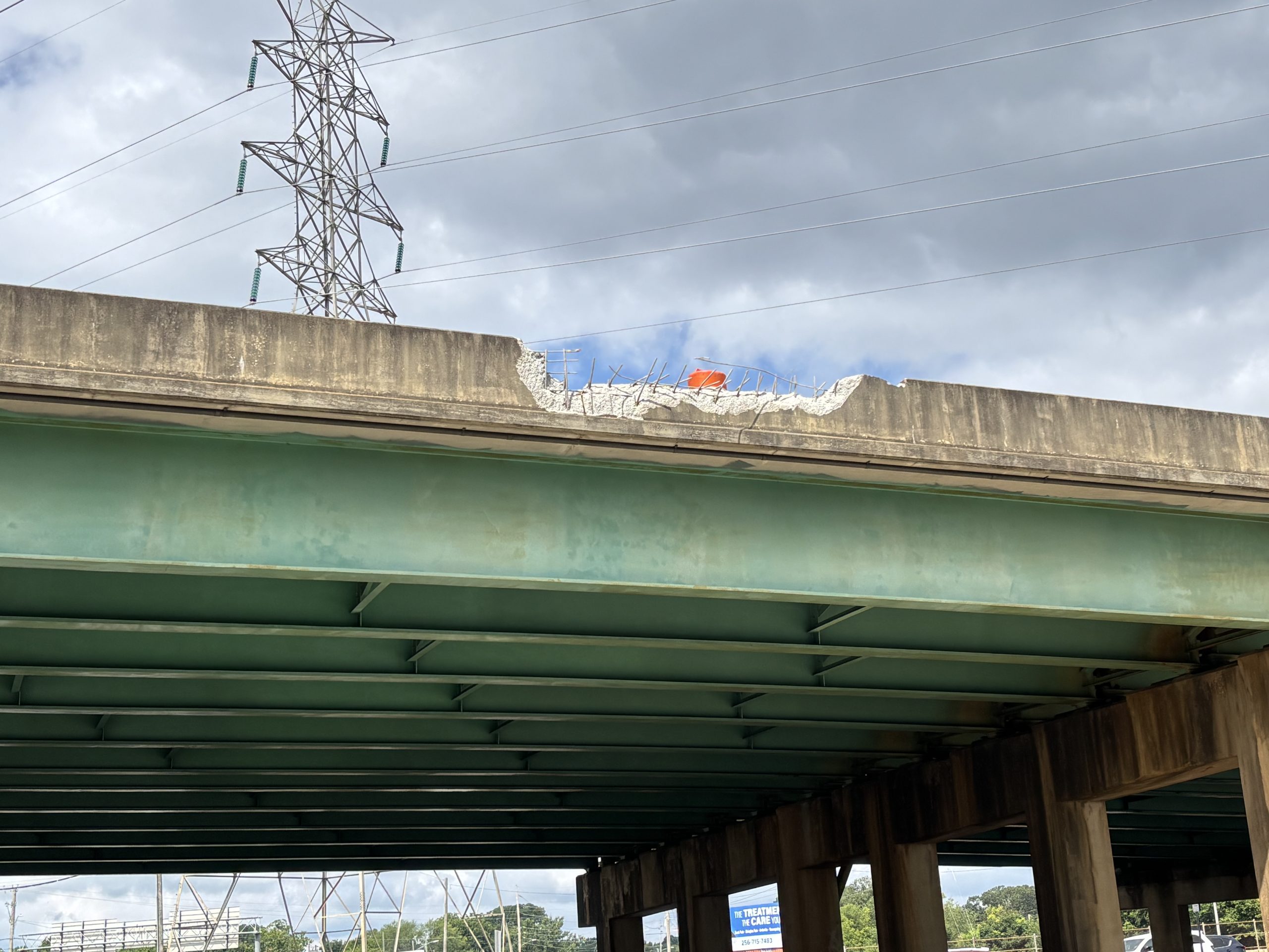An overpass with a damaged bridge rail.