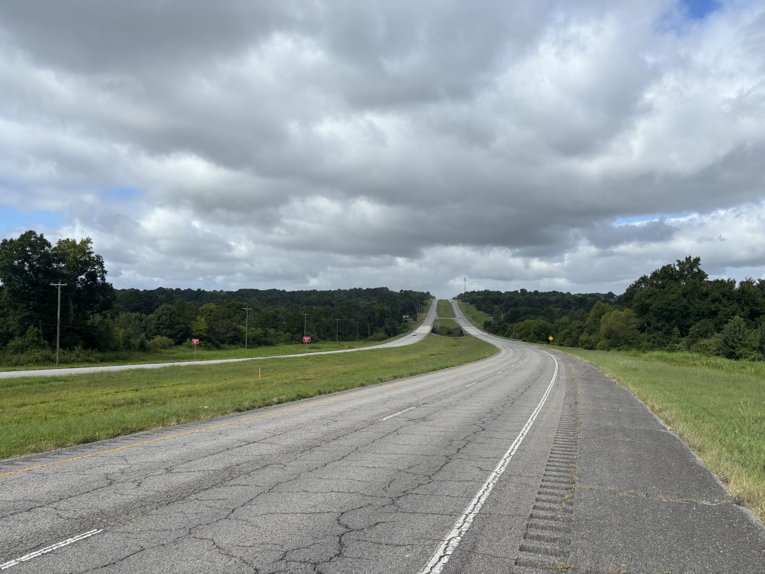 A cracked road under looming storm clouds.