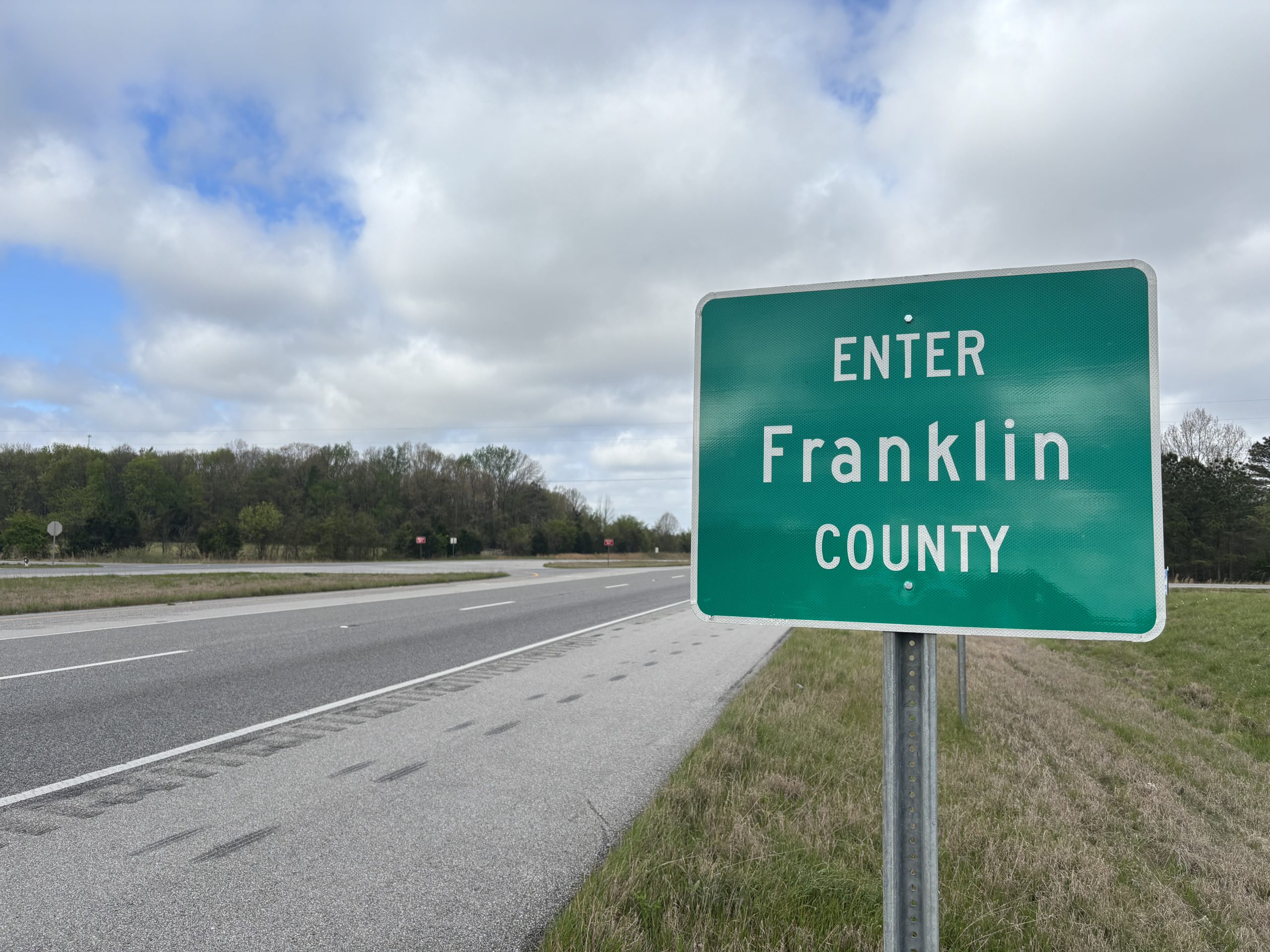 A sign on the shoulder of a divided four-lane highway reads "ENTER FRANKLIN COUNTY"