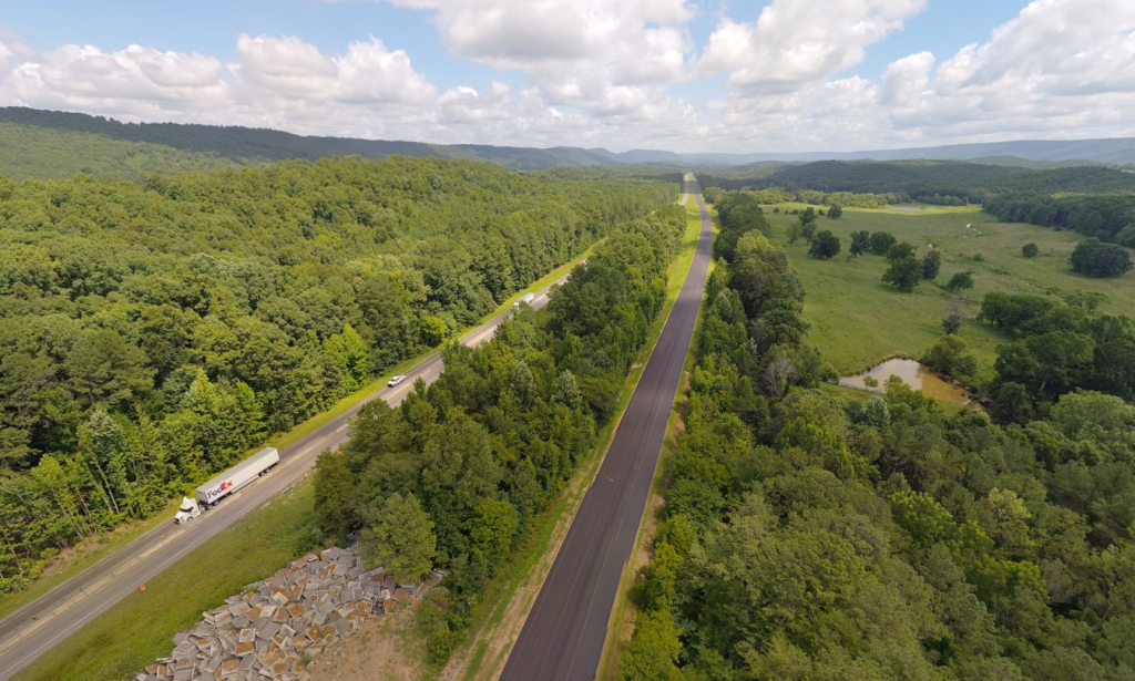 An aerial view showing two interstate roadways, with one carrying two-way traffic while the other is under construction.