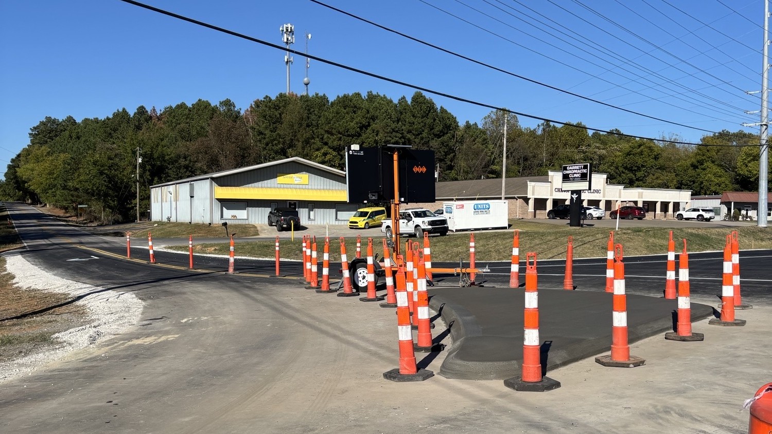 A new concrete island surrounded by cones on a road