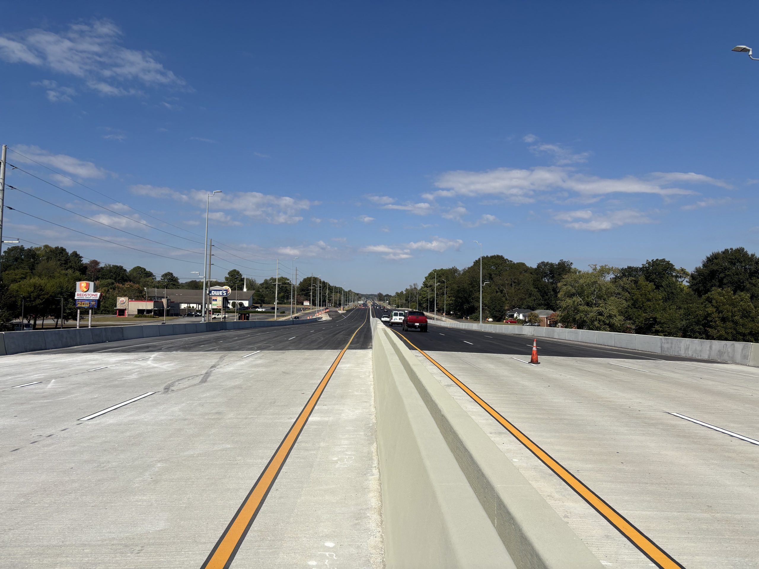 A concrete overpass and asphalt highway under a blue sky