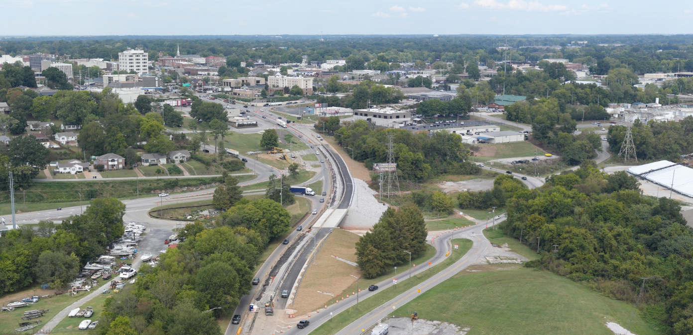 An aerial view of bridge construction with a city in the background