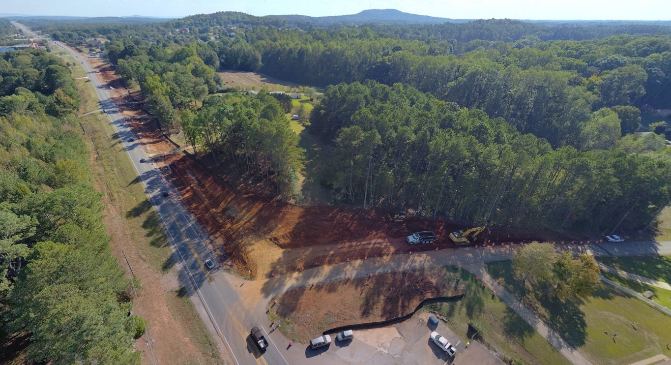 An aerial view of grading work near an intersection of a highway and a small road.